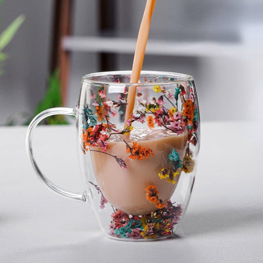 Elegant glass mugs with floral motifs on a coffee table.
