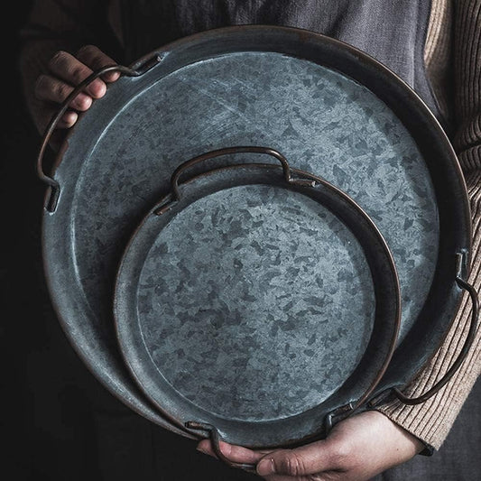 Vintage-style serving tray with a rustic finish on a dining table.
